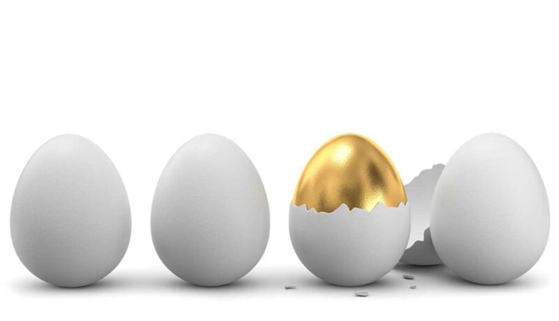 White eggs and solid gold egg with broken shell
